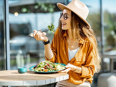 Woman smiling while eating meal outside