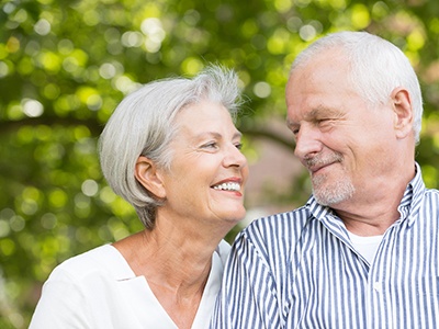 Senior man and woman smiling at each other outside