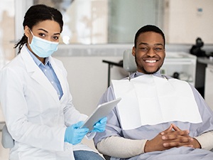 Dentist and patient smiling in dental office